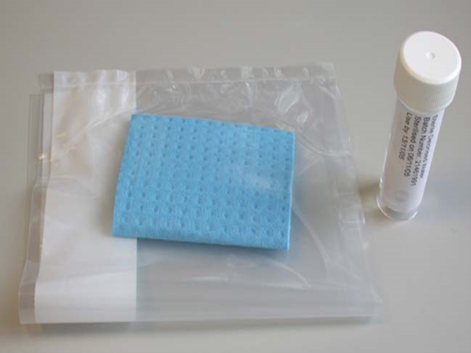 A sponge swab in a sterile plastic sample bag next to a tube of sterile diluent