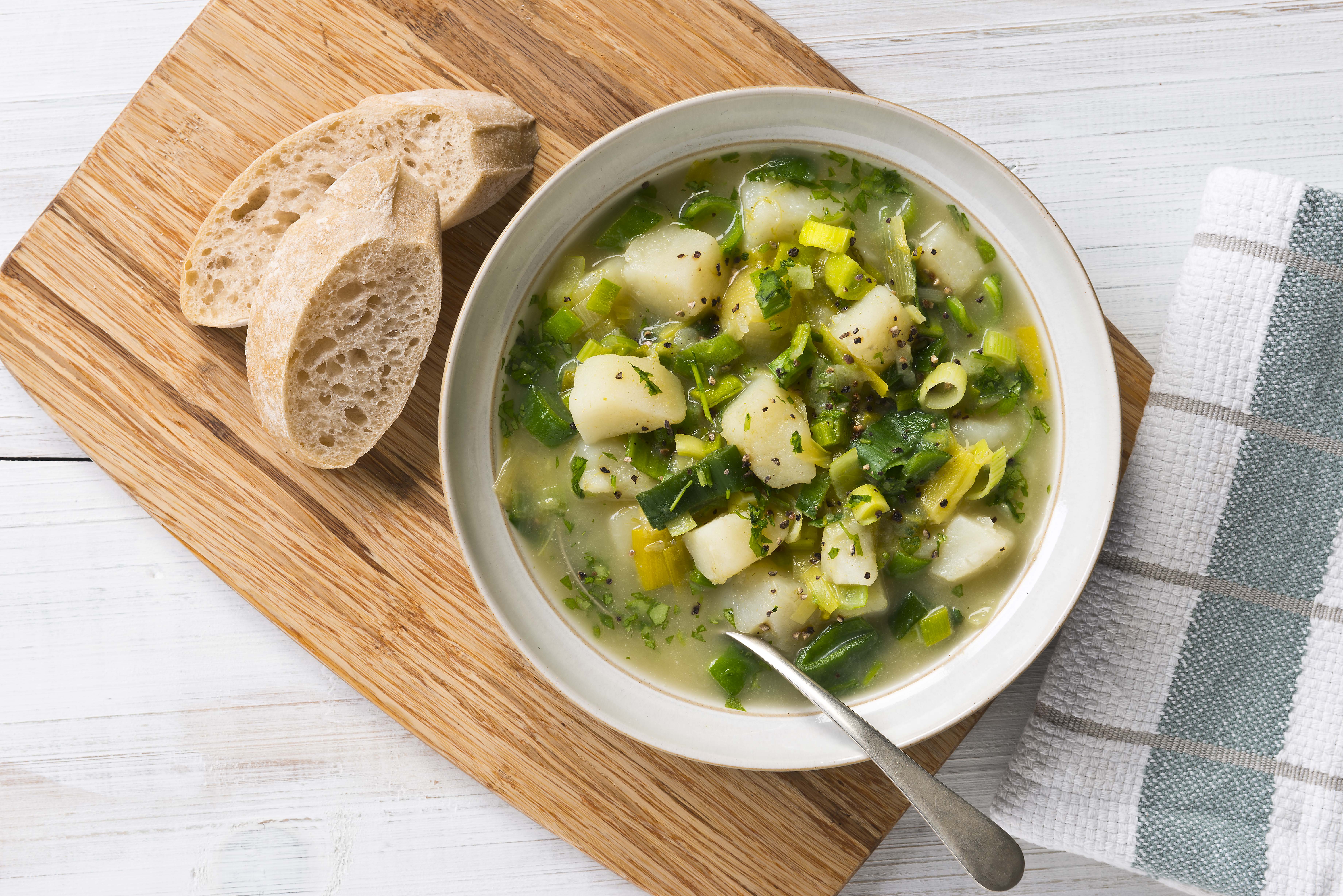 A bowl of leek and potato soup, served with crusty bread.