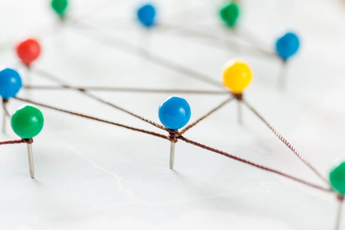 Image of drawing pins connected with string.