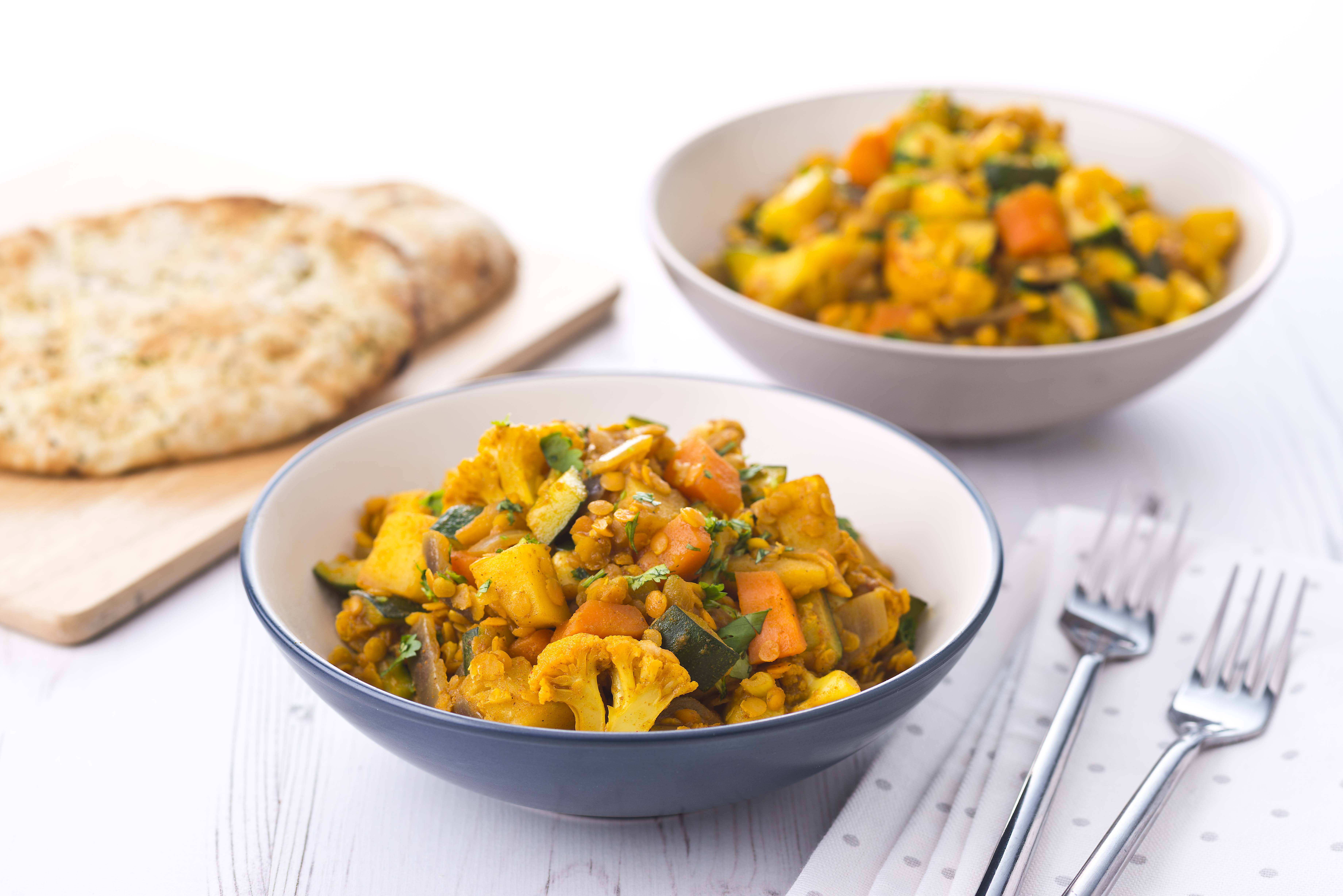 A serving of mixed vegetable and lentil curry with rice