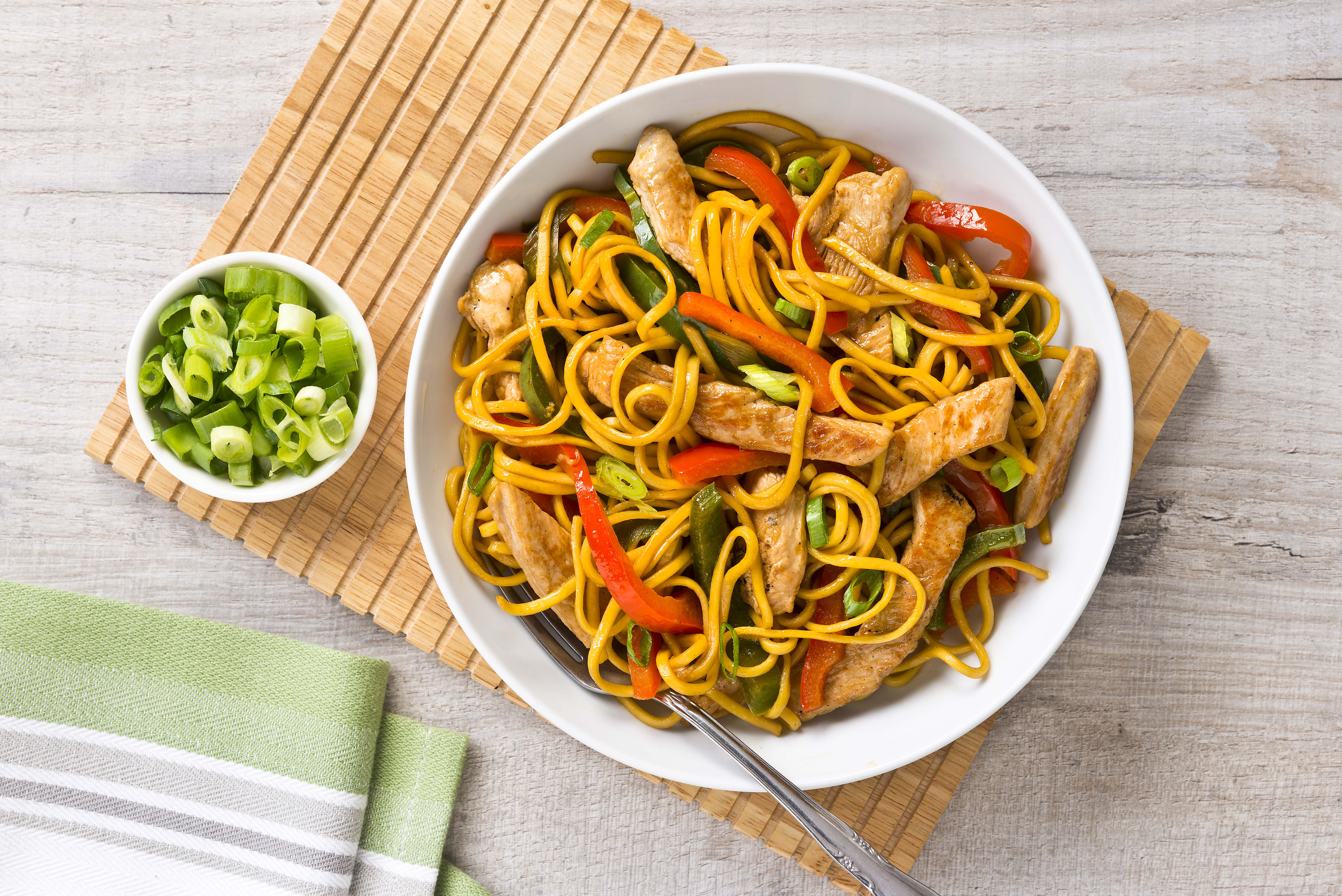 A bowl of turkey and pepper stir fry with a side garnish