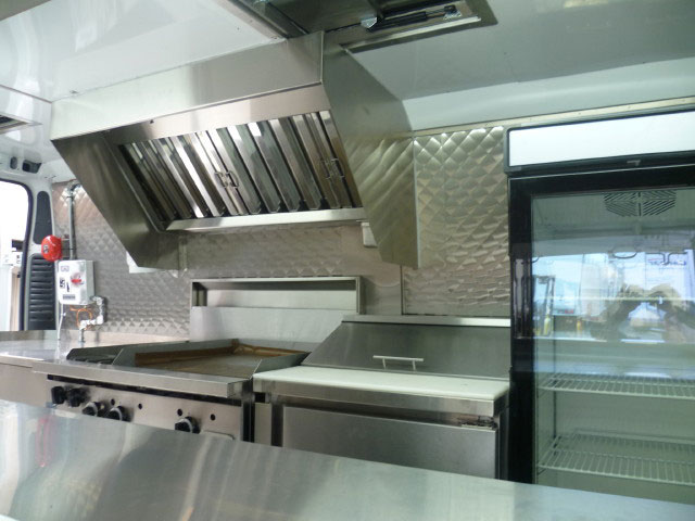 Interior of Papa's pizza and burger van. Shows the cooking and preparation surfaces as well as a fridge